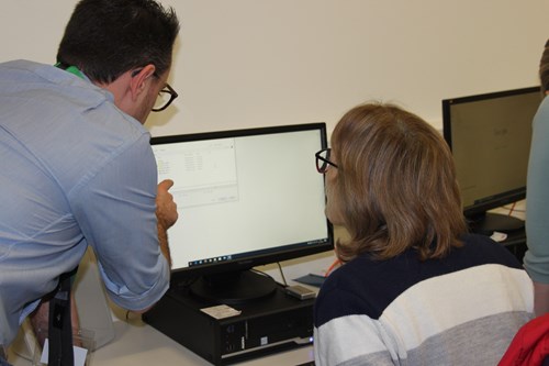 Image of an ABC employee helping a resident to save a document on their computer.